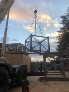 Rigging stands used for concrete processing. The image shows a series of metal rigging stands arranged to support and process concrete, with various tools and equipment visible in the background.