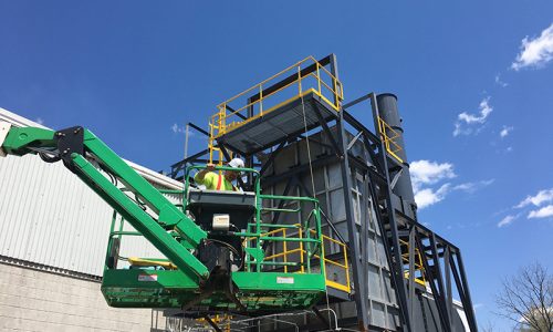 This image shows a constructions worker in proper safety gear getting the heavy machinery ready and in place to start project.