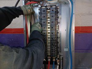 Closeup of someone working on wiring in a ul panel.