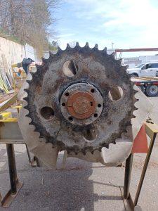 Reconditioning a large gear from a conveyor belt that is all rusted and grimy.