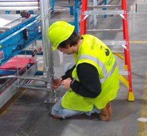 electrician with mj nester working on the electronics of a converyor